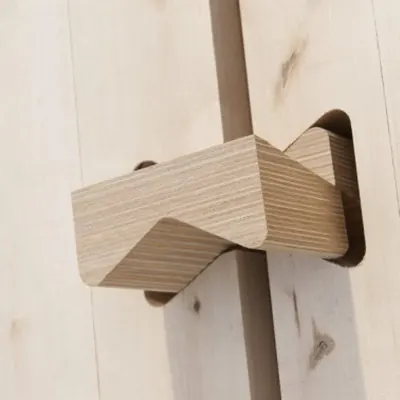 Ein Verbindungsmittel aus Schichtholz, in eine Holzwand eingeschoben; die Lagen des Sperrholzes sind an der Schnittkante zu sehen.