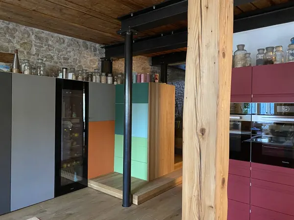 Küche zwischen Stein und Stahl — Eine Stütze nimmt die Last, die alte Wand bleibt Wand.